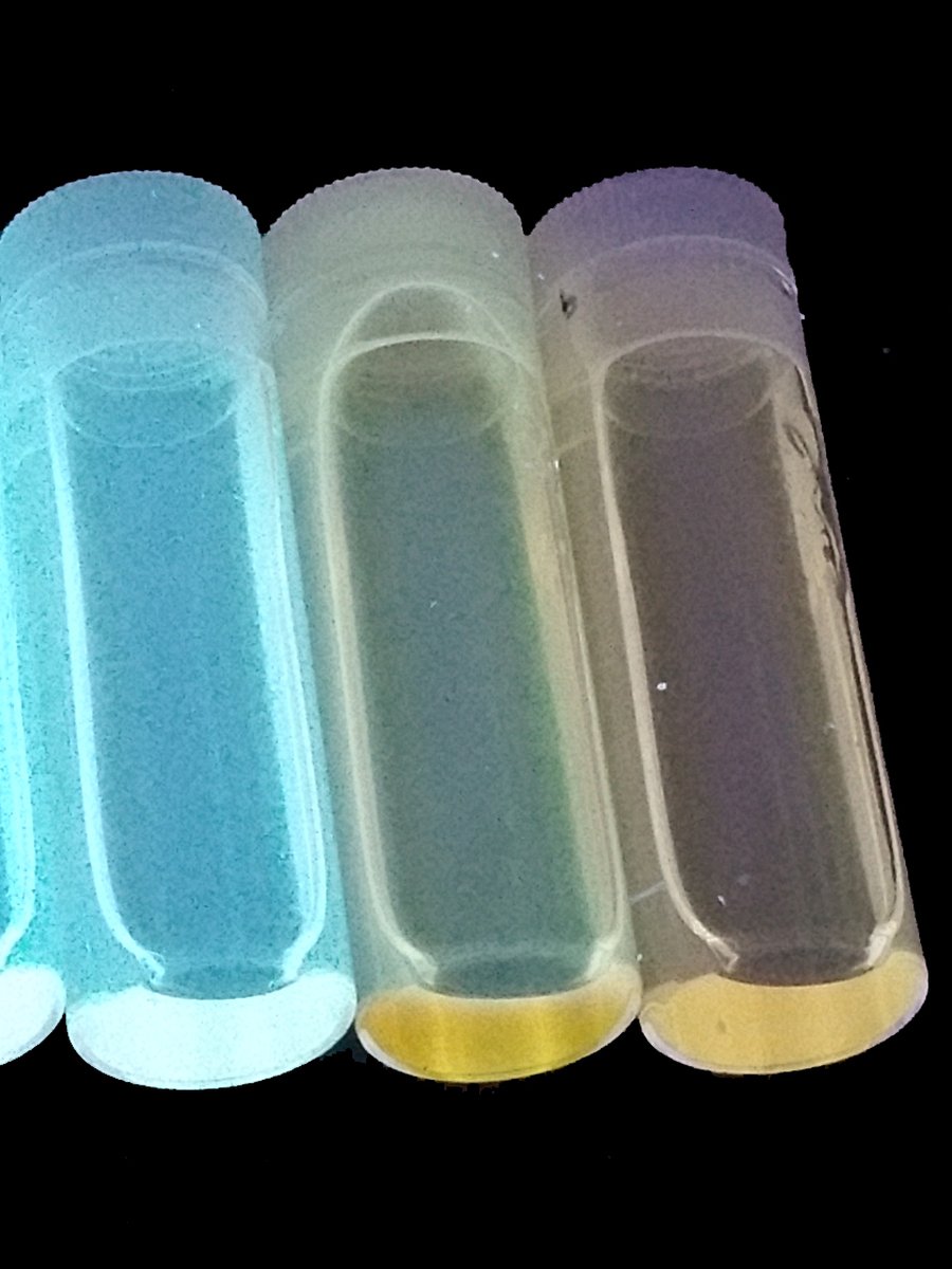 Carbon dot vials glowing in different colours under UV light
