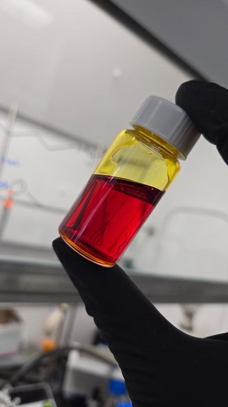 Two-phase vial with yellow and red layers during nanocrystal synthesis